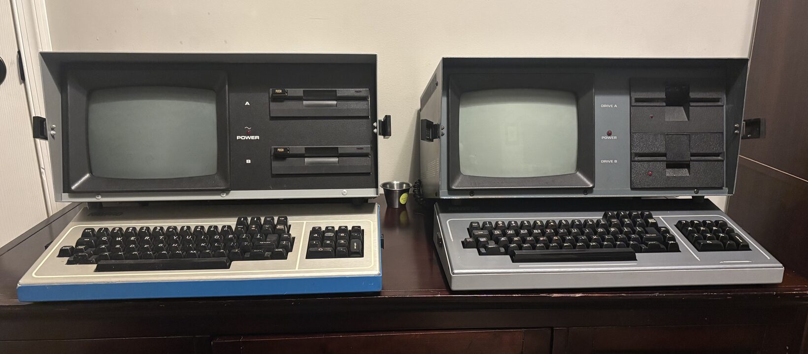 A Kaypro 2X (left) beside a Kaypro IV (right), both open on a desk.